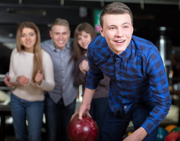 Foto gruppo di quattro amici in una pista da bowling divertendosi.