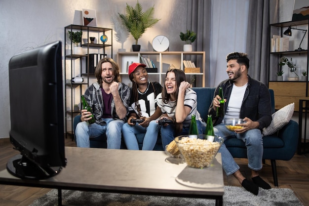 Group of four friends with joysticks playing video games