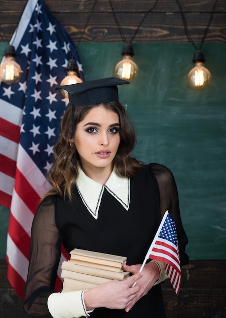 Group four happy people having waving American flag American flag blackboard Education university and school system in The United States of America Concept with US flag and graduation hat symbol