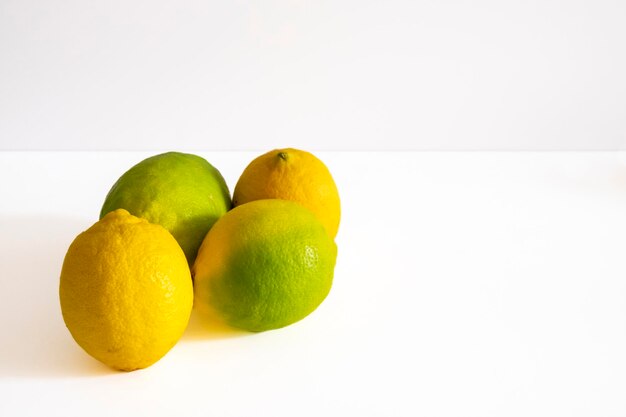 Группа из четырех целых желтых лимонов на белом фоне