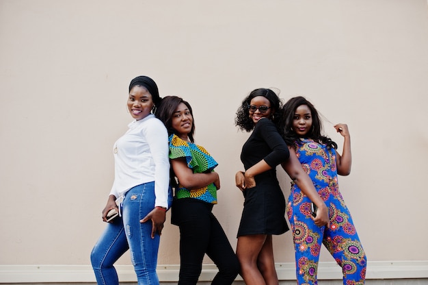 Photo group of four women posed outdoor against wall