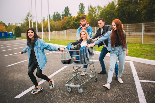 Group of four young diverse friends in jeanse outfit look carefree, young and happy on city's streets