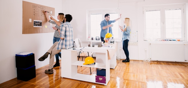 Group of four young focused successful business people sharing creative ideas for a break in the office while spending time together.