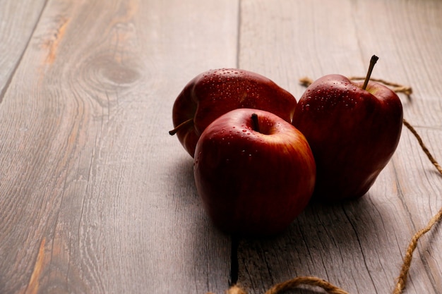 Группа свежих красных яблок на деревянном полу