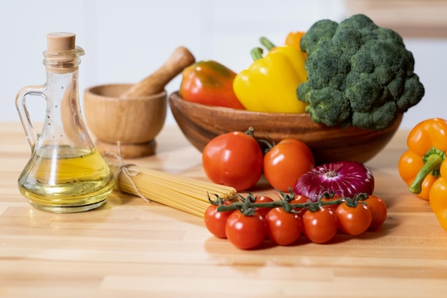 Gruppo di verdure fresche mature olio d'oliva e spaghetti sul tavolo da cucina