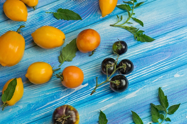青い木製の背景に新鮮なトマトのグループ