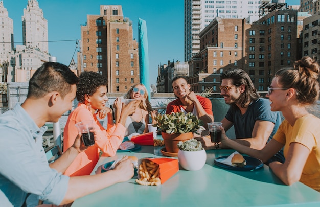 Gruppo di amici che spendono insieme tempo su un tetto a new york city, concetto di stile di vita con la gente felice