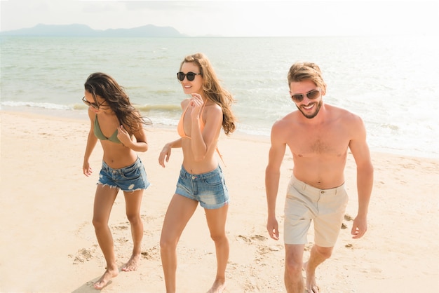 Gruppo di amici alla bella spiaggia tropicale in vacanza