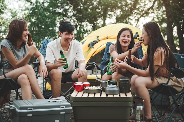 Group of friends at campground camping tent with friends\
diverse asian young family hangout together at camp yard outdoor\
activity and leisure on holiday