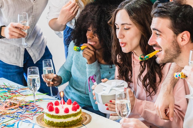 Foto un gruppo di amici festeggia un compleanno con una torta e candeline