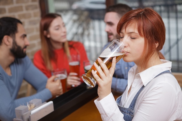 Group of friends drinking beer at the pub together