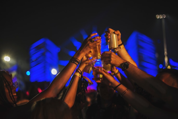 Photo group of friends drinking beers enjoying music festival together