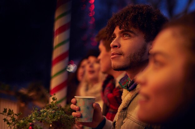 Group Of Friends Drinking Mulled Wine At Christmas Market