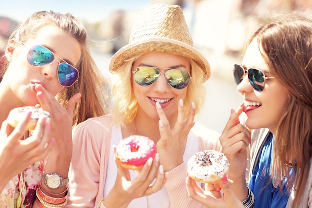 Group of friends eating donuts in the city