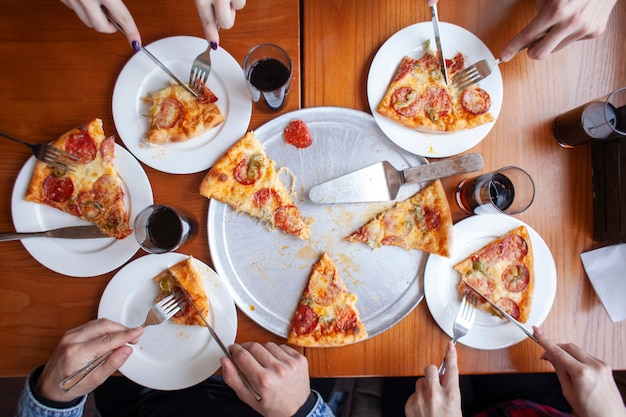 イタリアのピザを食べている友人のグループ