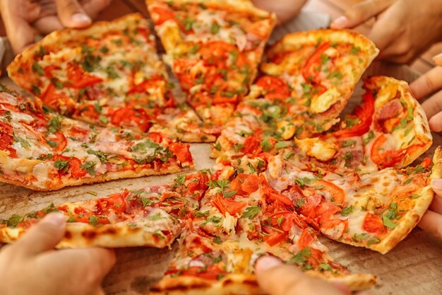 Foto gruppo di amici che mangiano pizza