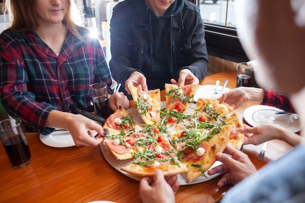 友人のグループがイタリアンピザを食べる