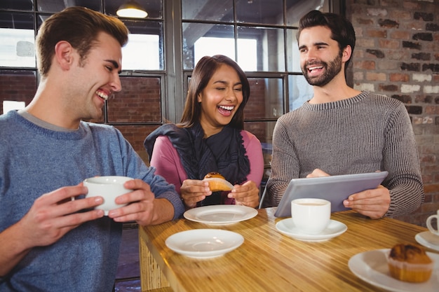 Group of friends enjoying a dessert with tablet