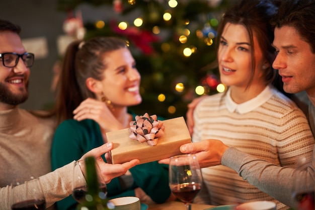 group of friends exchanging Christmas presents at home