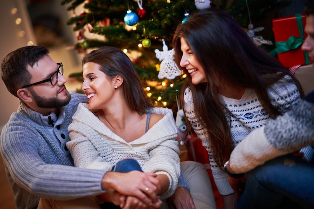 家でクリスマスプレゼントを交換する友人のグループ