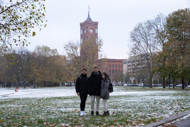 Rotes Rathaus を背景に雪が降るベルリンの公園での友人や家族のグループ