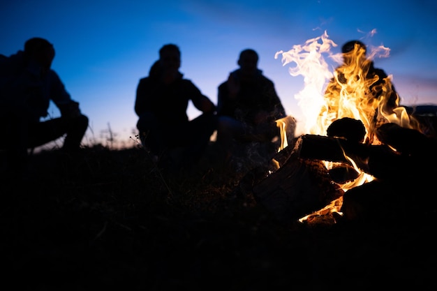 夜に火の周りに集まった友人のグループ