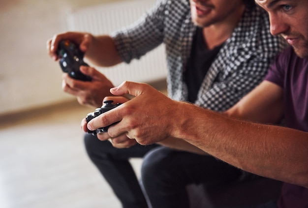 Foto un gruppo di amici si diverte a giocare a console in casa in soggiorno.