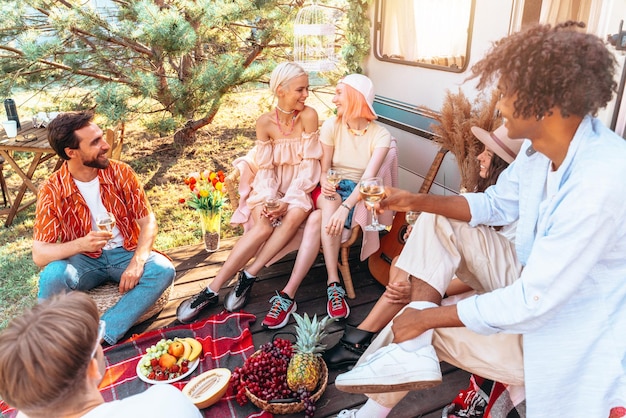 Group of friends have a picnic with a camper in a hot day