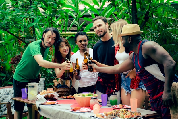 Group of friends having a barbecue party in nature. 