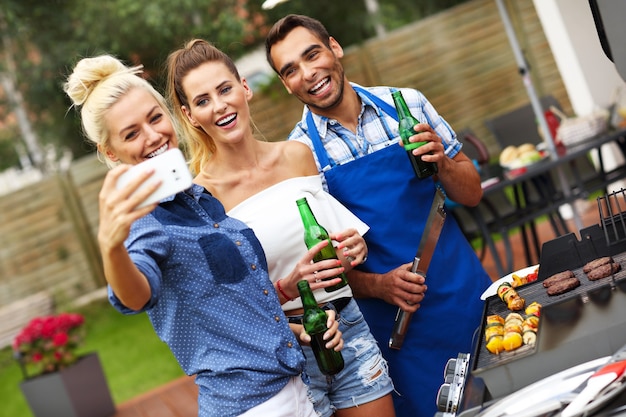 group of friends having barbecue party and taking selfie