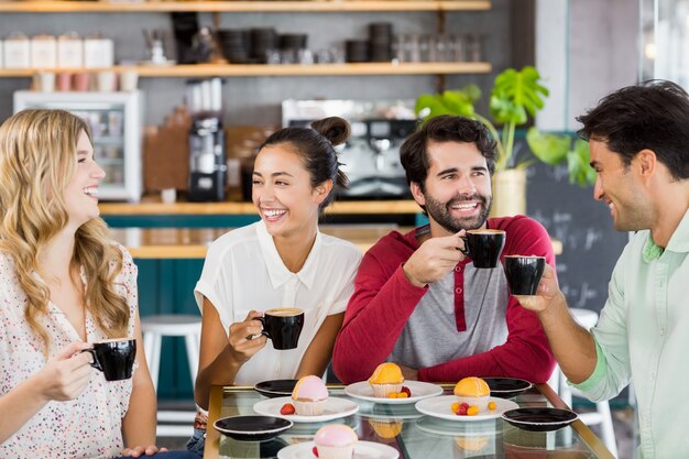 一緒に一杯のコーヒーを持っている友人のグループ