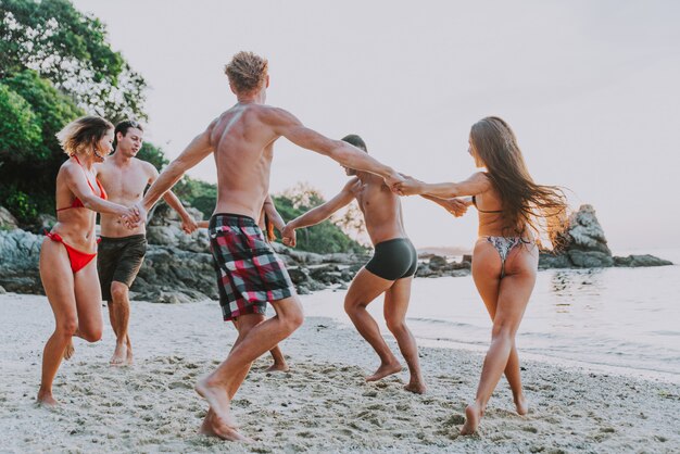 Group of friends having fun on the beach on a lonely island