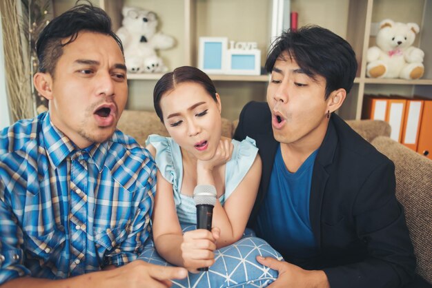 Group of friends having fun at living room singing a song together