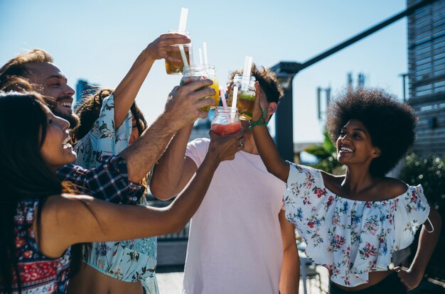 Photo group of friends having fun on the rooftop of a beautiful penthouse