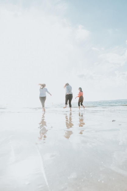 Group Of Friends Having Fun Running Along Winter Beach Together. Multi-ethnic. All girls club. Three women friends laughing together - female friendship concept. Lifestyle. Freedom Travel photography