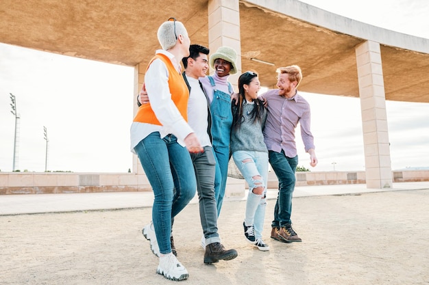 Group of friends having fun together and walking on the street in a sunny day