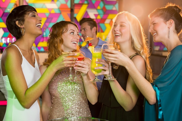 Group of friends having glass of cocktail in bar