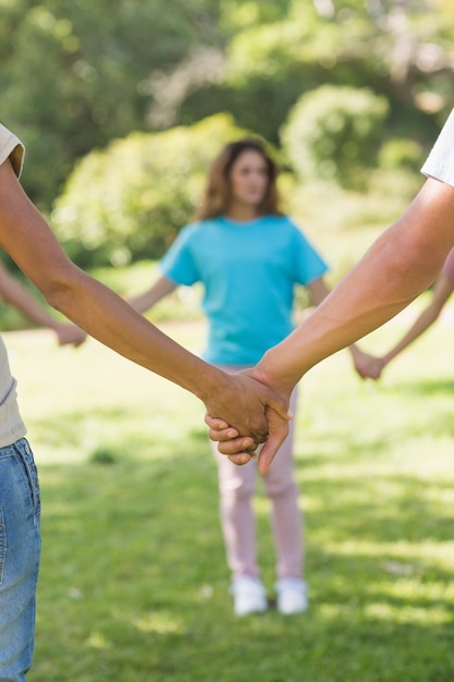 Group of friends holding hands in park