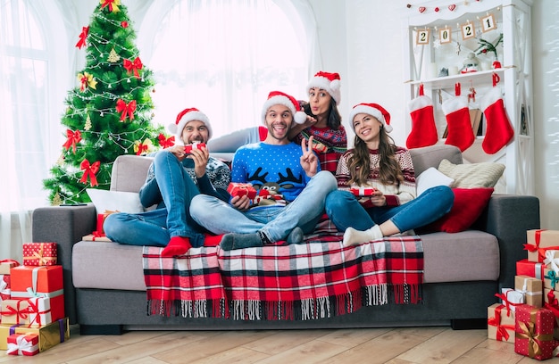 group of friends at home wearing santa hat