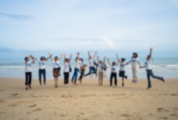 Photo group of friends jumping at the beach
