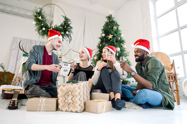 Photo group of friends laughing and drinkink champagne on christmas party