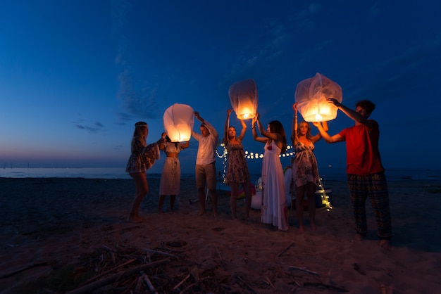 Group of friends lighting lanterns