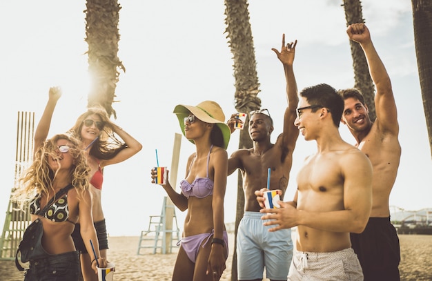 Group of friends making big party on the beach