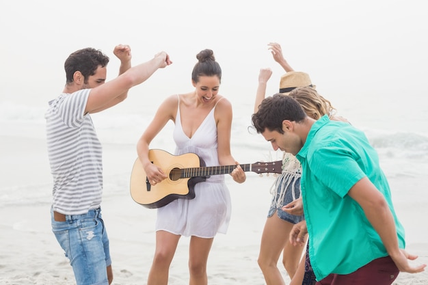 Group of friends playing guitar and dancing