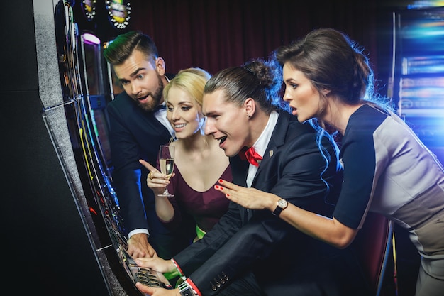 Foto gruppo di amici che giocano alle slot machine