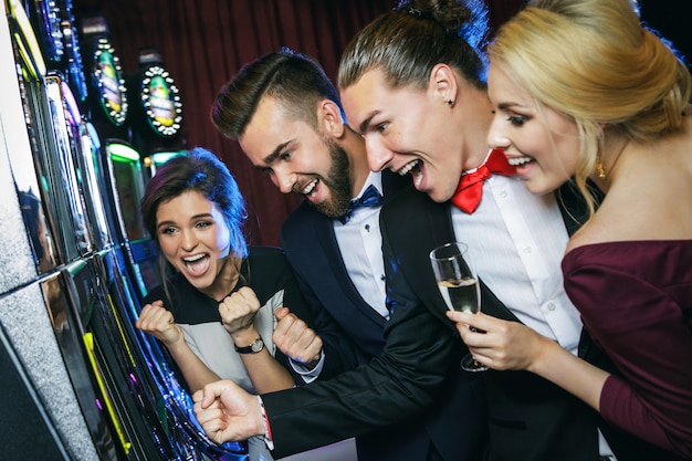 Foto gruppo di amici che giocano alle slot machine