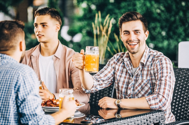 Group of friends at pub, toasting and laughing