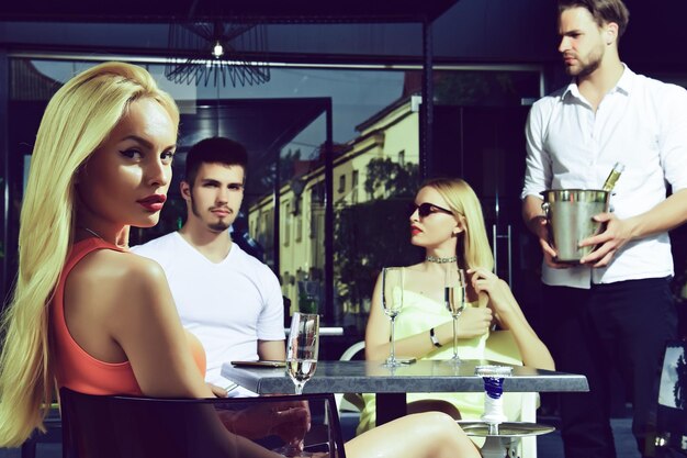 Group of friends relaxing in bar Group of cheerful young people talking to each other