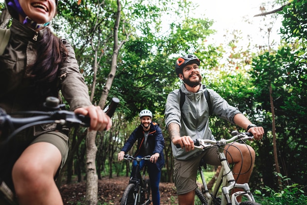 Group of friends ride mountain bike in the forest together