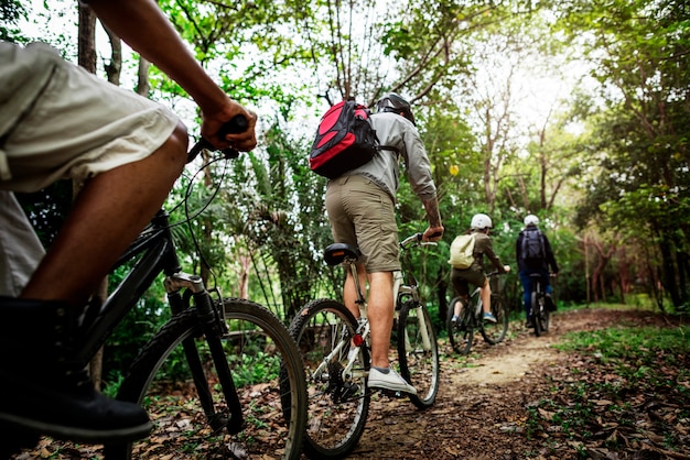 Foto il gruppo di amici guida insieme la mountain bike nella foresta